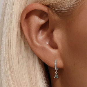 Gros plan d'une créole en argent S925 avec pendentif en agate mousse verte en goutte