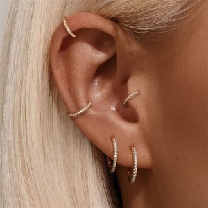 Gros plan détaillé d'un ensemble de piercings d'oreille en argent S925 doré avec zircons