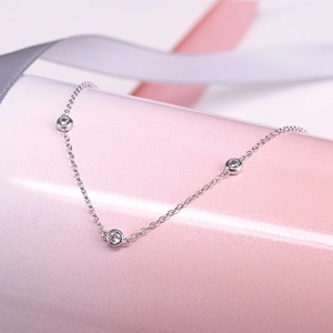 Close-up of a sterling silver chain necklace featuring three bezel-set round crystals