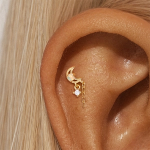 Nahaufnahme des goldenen Mondohrrings mit Opalstein und Hängerkette an einem Model
