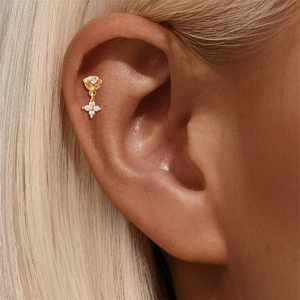 Macro-opname van goudkleurige S925 zilveren zonnebloem piercing met glanzende zirkonia