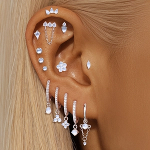 Nahaufnahme von S925 Silber Piercings-Set mit Mondstein-Klee und glänzenden Steckern