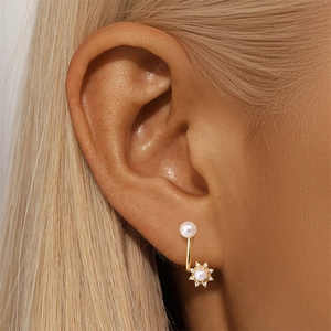 Detail of S925 silver pearl U-shaped ear cuff with sparkling sunburst crystal charms
