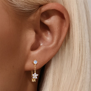 Close-up of S925 silver ear stud with blue gemstone and pearly flower pendant