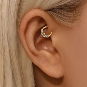 Detail shot of a S925 silver ear cuff with blue zircon stones in a crescent moon shape