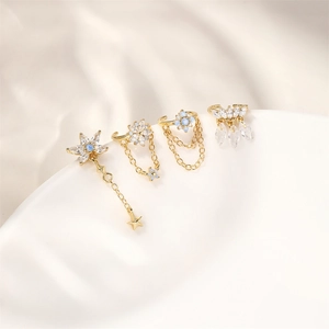 Detailed macro view of gold-plated flower and star ear cuffs with blue opal and zircons