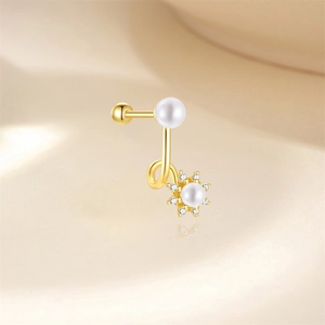 Close-up of golden spiral ear stud with twin pearls and sunflower diamond setting