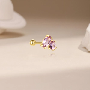 Detailed shot of golden screw back ear stud with two marquise cut purple gemstones