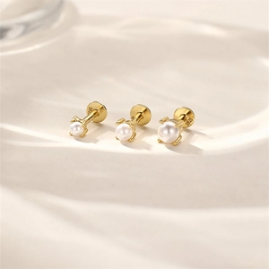 Vue macro de trois boucles d'oreilles en perles blanches avec tiges en argent S925