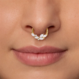 Macro shot of a gold nose ring with marquise zircon and opal stones worn by a model