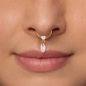 Close-up of a golden septum ring featuring a white heart opal and marquise-cut pendant