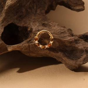 Detailed shot of golden marquise hoop with brown tiger eye beads and micro diamonds