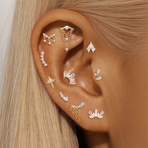 Macro view of gold s925 silver stud earrings set with cubic zirconia on female ear
