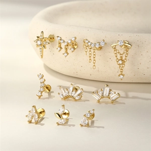 Macro detail of 10-piece gold S925 silver stud earring set with zircon in a ceramic tray