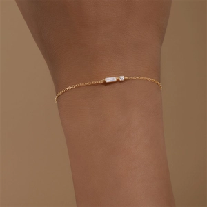 Bracciale minimalista in argento S925 dorato con zirconi quadrati indossato su un polso