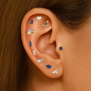 Detail of S925 silver dinosaur stud earrings with colorful zircons on ear model