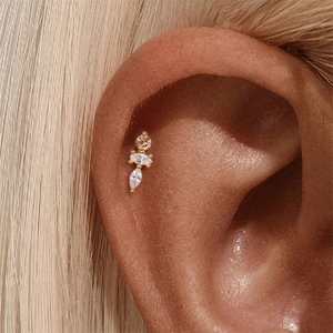 Close-up of gold cartilage stud earring with pink and clear marquise zircons