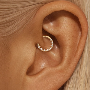 Macro shot of gold geometric rhodium-plated ear cuff with white crystals on ear