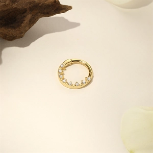 Detailed macro view of golden S925 silver nose ring with zircons and clicker mechanism