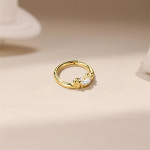 Macro detail of gold s925 silver nose ring with clear zircon and hallmark engraving