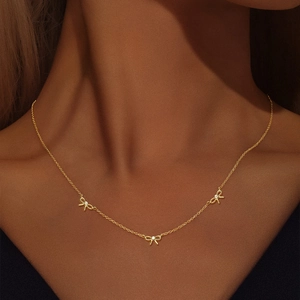 Gros plan d'un collier en argent s925 doré avec trois pendentifs nœuds en zircon