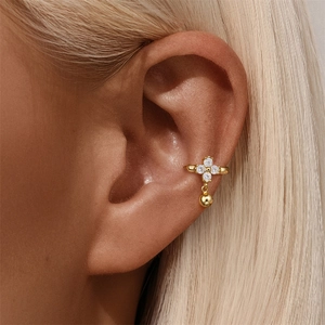 Detail of gold ear cuff with marquise crystals and round bead drop on model's ear