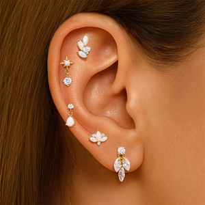 Detail of S925 silver 18K gold ear piercing set with opal and cubic zirconia stones