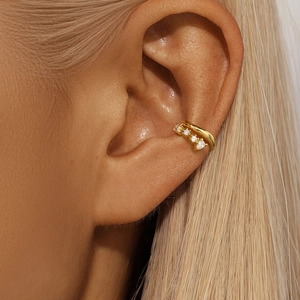 Λεπτομέρεια από επιχρυσωμένο σκουλαρίκι ear cuff με λαμπερές πέτρες ζιργκόν