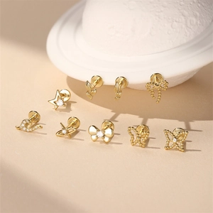 Macro shot of gold S925 sterling silver bow and star studs with white zircon details