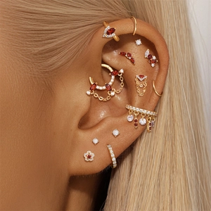Detailed view of S925 silver ear cuff with red garnet and crystal charms on a model