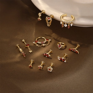 Detailed set of gold earrings with red stones, star motifs, and elegant hanging chains