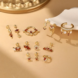 Macro shot of S925 sterling silver gold-plated ear cuffs and nose rings with red gems