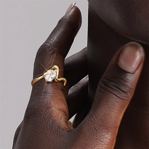 Nahaufnahme eines Goldrings mit ovalem Zirkon und Wellenband für elegante Damen