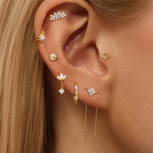 Detail von Gold-Ohrpiercing-Set mit Quasten, Kreuz und Zirkonia am Modell