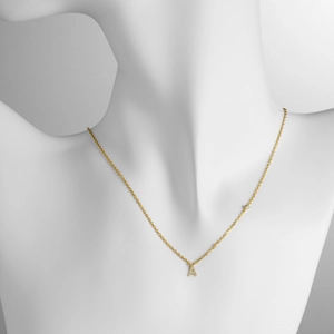 Close-up of gold S925 silver necklace with A-letter pendant and sparkling zircon stones