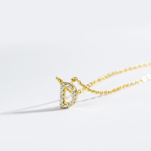 Macro view of gold plated letter D pendant necklace with shimmering cubic zirconia stones