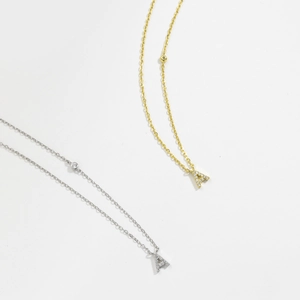Detailed macro of S925 silver and gold plated necklaces with micro-pave letter A pendants