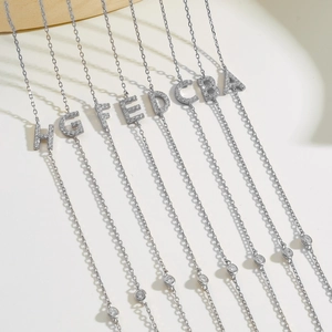 Detail of silver S925 necklaces with zircon-encrusted letters A to H on thin chains