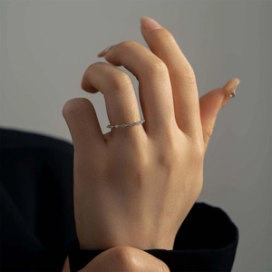 Close-up of minimalist S925 sterling silver thin ring with tiny pavé crystals on finger