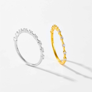 Detailed close-up of S925 sterling silver and gold rings with sparkling cubic zirconia pavé
