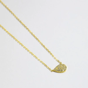 Detailed view of S925 hallmark on gold plated pear-shaped pendant with pave crystals