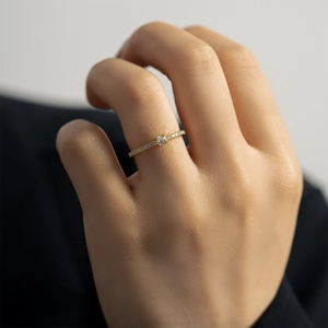 Minimalist S925 sterling silver gold ring with round zircon stones on a female hand model