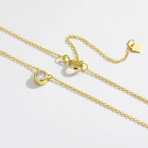Macro detail of gold plated S925 sterling silver necklace with round cubic zirconia pendant