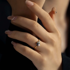 Anillo de plata S925 con piedras azules y púrpuras en la mano de una modelo femenina