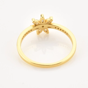 Detalle de anillo de flor dorada con pétalos huecos y engaste de piedras finas
