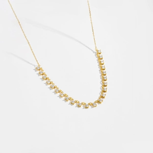 Close-up of golden S925 sterling silver necklace with sparkling round zircon stones