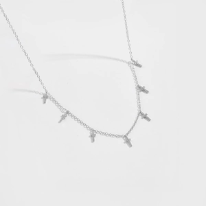 Détail d'un collier en argent S925 avec plusieurs petits pendentifs croix en zircon