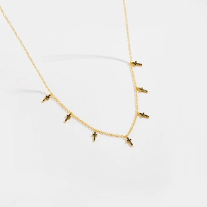 Collier doré avec sept petits pendentifs en forme de croix en pierres noires serties