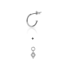 Detailed view of silver hoop earring and geometric rhombus pendant with white zircon