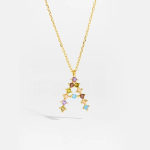 Macro shot of gold letter A pendant with colorful zircon stones on fine chain